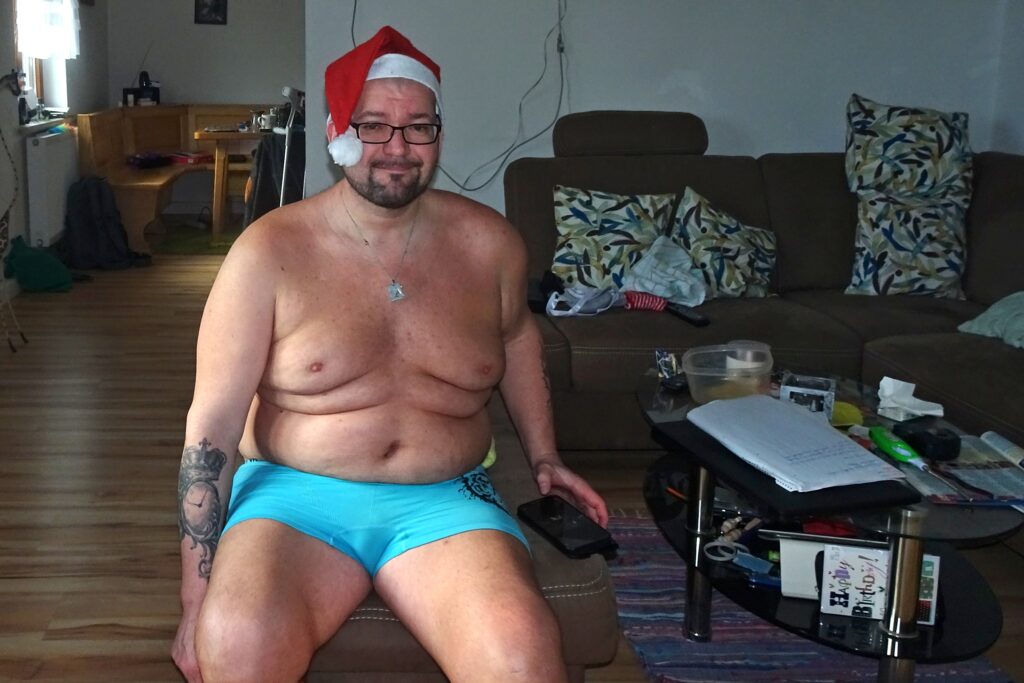 Nackt mit Weihnachtsmütze im Wohnzimmer