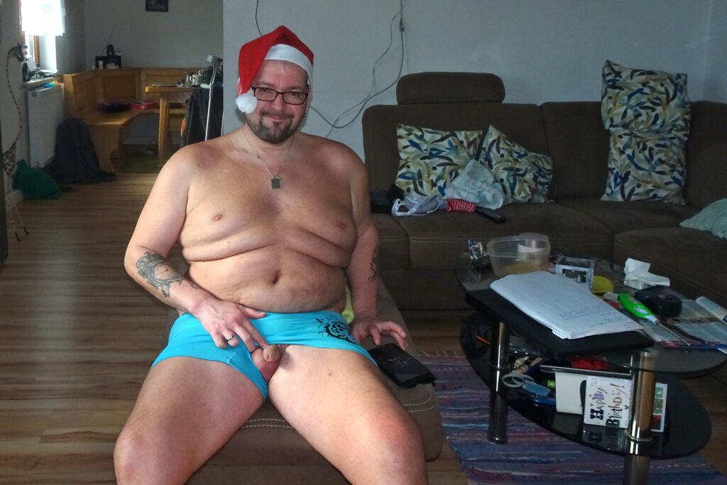 Nackt mit Weihnachtsmütze im Wohnzimmer